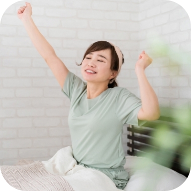 寝起きで伸びをする女性